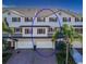 Charming two-story townhouse with red shutters, garages, and lush palm trees surrounding the property at 3409 10Th W Ln, Palmetto, FL 34221