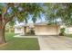 Charming single-story home with a two-car garage, manicured lawn, and mature tree providing ample shade at 3415 68Th Street E Cir, Palmetto, FL 34221