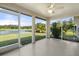 Covered and screened lanai showcasing views of a serene pond and tropical foliage at 3415 68Th Street E Cir, Palmetto, FL 34221