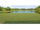 Lush green backyard leads to a serene pond, surrounded by natural greenery and trees at 3415 68Th Street E Cir, Palmetto, FL 34221