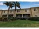 Exterior view of the rear of the townhouse with screened patio, lush lawn and landscaped privacy hedges at 3707 45Th W Ter # 104, Bradenton, FL 34210