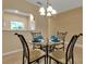 Cozy formal dining room features glass table and chairs adjacent to a kitchen pass-through at 3707 45Th W Ter # 104, Bradenton, FL 34210