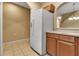 Well-lit kitchen featuring a white refrigerator, tile flooring, and wooden cabinets at 3707 45Th W Ter # 104, Bradenton, FL 34210