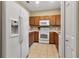 A kitchen displaying white appliances, wood cabinets, and an eat-in kitchen with tile floors at 3707 45Th W Ter # 104, Bradenton, FL 34210