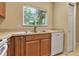 Kitchen featuring tile flooring, wood cabinets, stainless sink and view of green landscape through window at 3707 45Th W Ter # 104, Bradenton, FL 34210