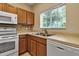 An eat-in kitchen featuring wooden cabinets, stainless sink, and window views at 3707 45Th W Ter # 104, Bradenton, FL 34210