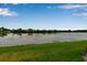 Scenic view of the pond with lush green grass in the foreground under a clear blue sky at 3707 45Th W Ter # 104, Bradenton, FL 34210