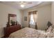 Cozy bedroom with a queen-size bed, dresser with mirror, and a window with natural light at 3835 W Price Blvd, North Port, FL 34286