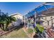 Back exterior view of home, with a screened-in patio, detached shed, and lush landscaping at 3835 W Price Blvd, North Port, FL 34286