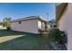 Side exterior view showcasing the home's stucco siding and adjacent enclosed lanai area at 3835 W Price Blvd, North Port, FL 34286