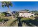 Back exterior showcasing the lawn, screened-in patio, and the home's well-maintained landscaping at 3835 W Price Blvd, North Port, FL 34286