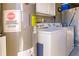 Functional laundry room with modern washer and dryer, storage cabinets, and water heater at 3835 W Price Blvd, North Port, FL 34286