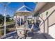 Enclosed patio with seating, offering an outdoor dining area and views of the manicured backyard and shed at 3835 W Price Blvd, North Port, FL 34286
