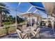 Covered patio with outdoor dining area and views of the lush landscaping in the backyard at 3835 W Price Blvd, North Port, FL 34286