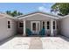 Inviting home entrance with decorative door, white columns, accent chairs, and well maintained stone front yard at 417 Park Lane Dr, Venice, FL 34285