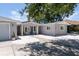 Charming single-story home featuring a well-maintained yard, neutral color palette, and inviting front entrance with blue chairs at 417 Park Lane Dr, Venice, FL 34285