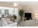 Comfortable living room with neutral walls, ceiling fan, various seating options, and sunny view from attached Florida room at 417 Park Lane Dr, Venice, FL 34285