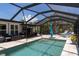 Sparkling pool with covered and screened lanai, surrounded by lush tropical landscaping at 417 Park Lane Dr, Venice, FL 34285