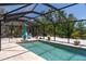 Refreshing pool inside screened enclosure, surrounded by lush landscaping and lounge area at 417 Park Lane Dr, Venice, FL 34285