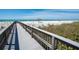 Walkway leading to a pristine white sand beach with stunning ocean views and tiki umbrellas at 435 L Ambiance Dr # Ph-J, Longboat Key, FL 34228