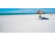Beautiful beach with thatched umbrellas and lounge chairs, perfect for relaxing by the ocean at 435 L Ambiance Dr # Ph-J, Longboat Key, FL 34228