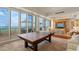 Bright living room features a ping pong table and floor to ceiling windows offering ocean views at 435 L Ambiance Dr # Ph-J, Longboat Key, FL 34228