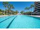 Large, inviting outdoor pool surrounded by palm trees and lounge chairs at 435 L Ambiance Dr # Ph-J, Longboat Key, FL 34228