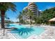 Stunning pool with a backdrop of a luxurious beachfront condo and swaying palm trees at 435 L Ambiance Dr # Ph-J, Longboat Key, FL 34228