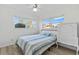 Bright bedroom with white walls, wood-look floors, ceiling fan, and ample natural light from the two windows at 4519 Brooksdale Dr, Sarasota, FL 34232
