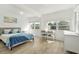 Sunlit bedroom with a calm ambiance, featuring wood paneling, an art piece, and a small table with chairs at 4519 Brooksdale Dr, Sarasota, FL 34232