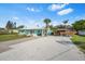Inviting home exterior with a gravel driveway, covered boat storage, palm trees, and a well-maintained lawn at 4519 Brooksdale Dr, Sarasota, FL 34232