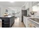 Cozy kitchen with white cabinets and countertops, stainless steel refrigerator, island and light wood flooring at 4519 Brooksdale Dr, Sarasota, FL 34232