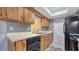 Kitchen featuring wood cabinets, a double sink, black appliances and neutral countertops at 4611 Spahn St, Sarasota, FL 34232