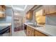 Galley kitchen with wood cabinets, black appliances, open to dining and living rooms at 4611 Spahn St, Sarasota, FL 34232