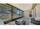 A large screened porch looks out on the lawn, surrounded by a backyard fence and trees at 4611 Spahn St, Sarasota, FL 34232