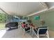 Covered patio with a grill, comfortable seating, and an outdoor TV, creating a perfect space for relaxation and entertainment at 4907 18Th W Ave, Bradenton, FL 34209