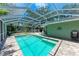 Relaxing screened-in pool area with brick patio, lounge chairs, and lush landscaping, ideal for outdoor enjoyment and privacy at 4907 18Th W Ave, Bradenton, FL 34209