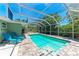 Beautiful screened-in pool area with brick patio, lounge chairs, and lush landscaping, perfect for outdoor relaxation and fun at 4907 18Th W Ave, Bradenton, FL 34209