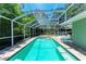 Inviting screened-in pool area with brick patio, lounge chairs, and lush landscaping, perfect for relaxation and entertaining at 4907 18Th W Ave, Bradenton, FL 34209