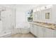 Elegant bathroom features marble tiling, a soaking tub, double vanity sinks, and plenty of natural light at 516 Tamiami S Trl # 306, Nokomis, FL 34275