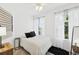 Well-lit bedroom with neutral tones, hardwood floors, two large windows, and a comfortable queen-sized bed at 516 Tamiami S Trl # 306, Nokomis, FL 34275
