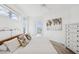 Bright bedroom with a white bed, light wood floors, and a view of the water from the balcony at 516 Tamiami S Trl # 306, Nokomis, FL 34275