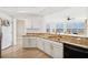 Open concept kitchen featuring granite countertops, white cabinetry, and wood flooring at 516 Tamiami S Trl # 306, Nokomis, FL 34275