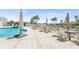 Community outdoor pool with an adjacent patio area and several tables under umbrellas overlooking the water at 516 Tamiami S Trl # 306, Nokomis, FL 34275