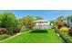 A beautifully landscaped backyard with green turf and a charming white picket fence and umbrella at 5238 Susan Ave, Sarasota, FL 34231