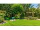 Expansive backyard with lush greenery, mature trees, and a peaceful seating area at 5238 Susan Ave, Sarasota, FL 34231