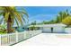 Charming light-blue home with a white picket fence, palm tree, and a driveway leading to a two-car garage at 5238 Susan Ave, Sarasota, FL 34231