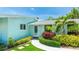Front exterior entrance with lush landscaping and a modern light-blue exterior at 5238 Susan Ave, Sarasota, FL 34231