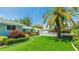 A vibrant front yard featuring manicured landscaping, green turf, and a quaint white picket fence at 5238 Susan Ave, Sarasota, FL 34231