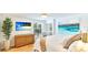 Comfortable main bedroom with wood floors, wicker dresser, beach artwork, and access to a private balcony at 5238 Susan Ave, Sarasota, FL 34231